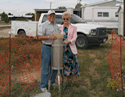 cooperative observer in Carlsbad, New Mexico standing beside a rain gauge