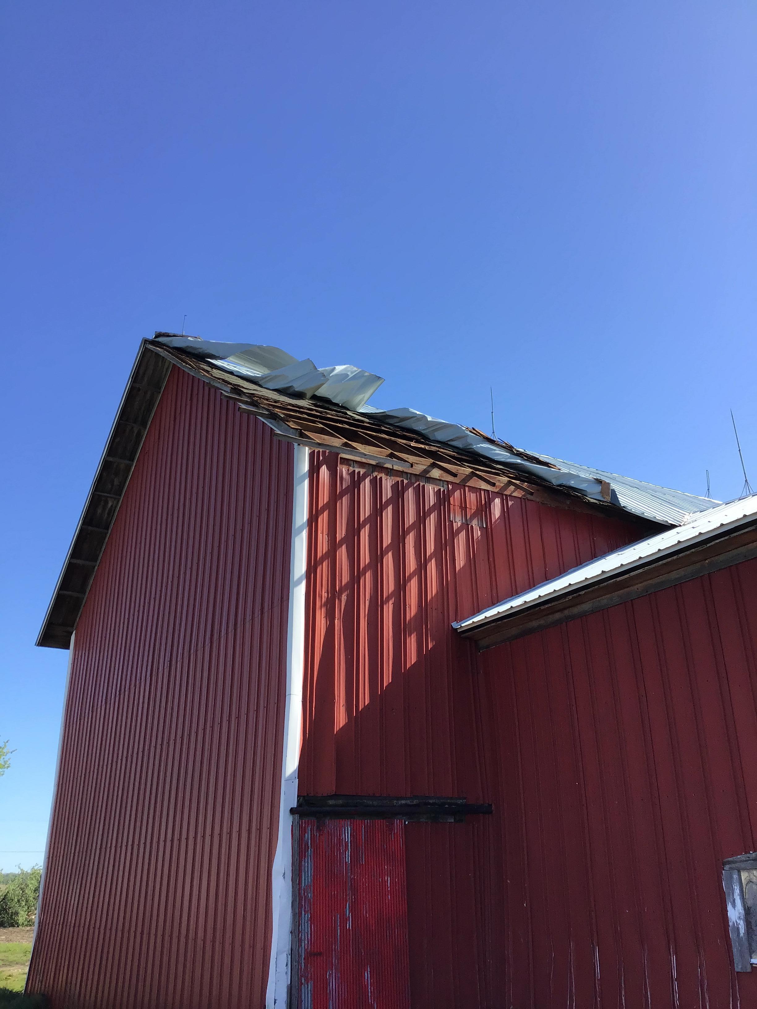 Photo of metal roof paneling peeled off top of barn