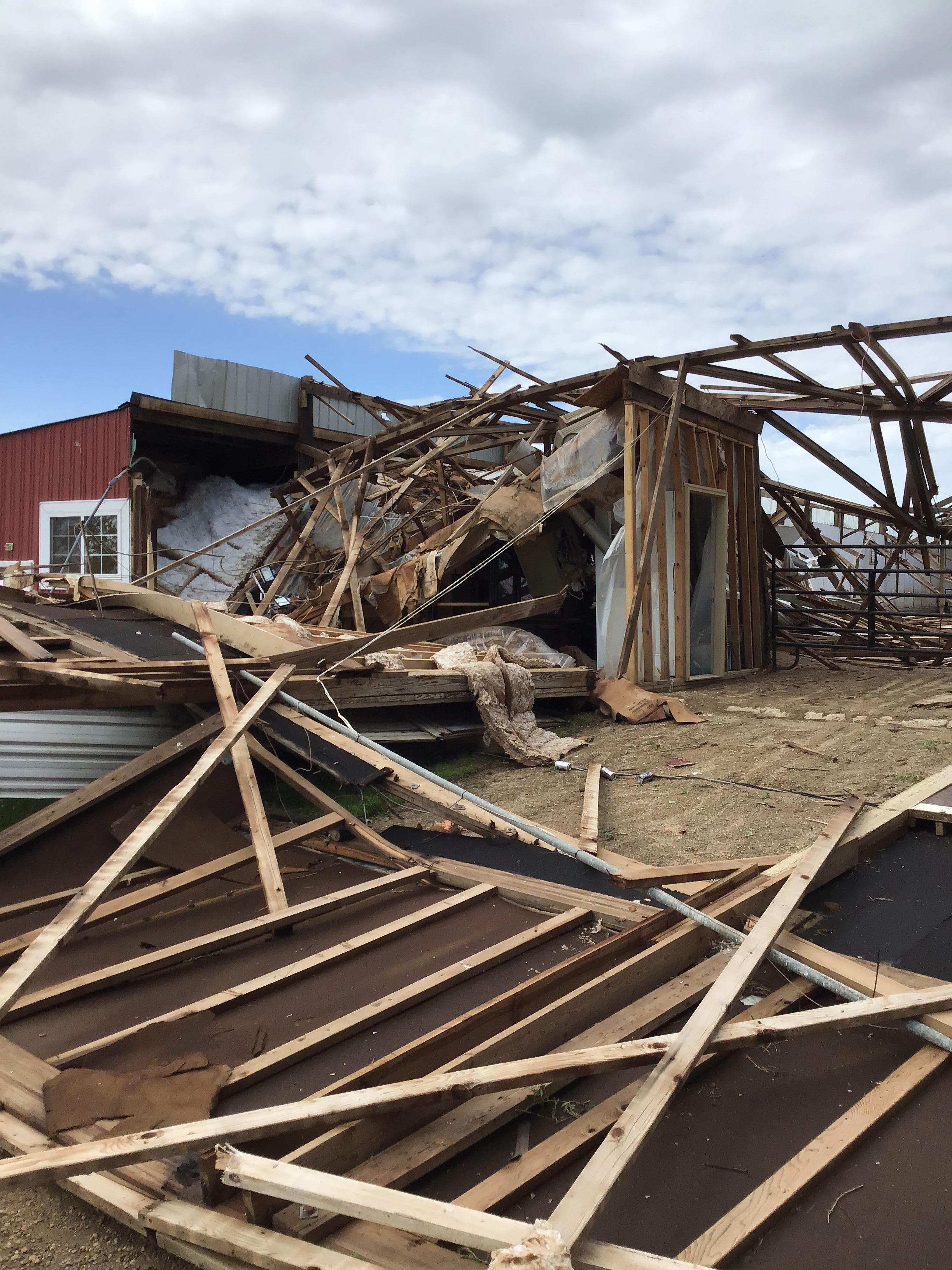 Photo of horse stable with the roof collapsed and walls blown in