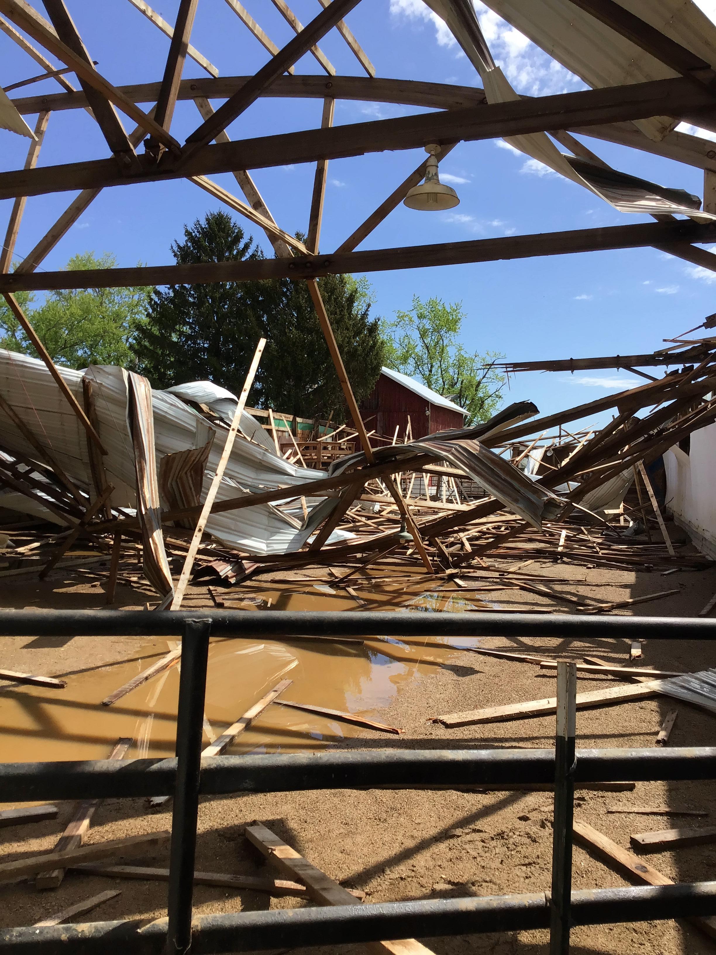 Photo of horse stable with the roof collapsed and walls blown in