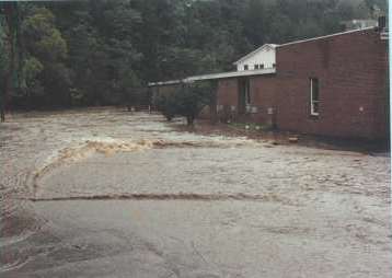 Looking downstream in the school’s front parking lot showing that the water has come down significantly.