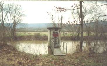 The gage with farmlands beyond and the river back in its banks