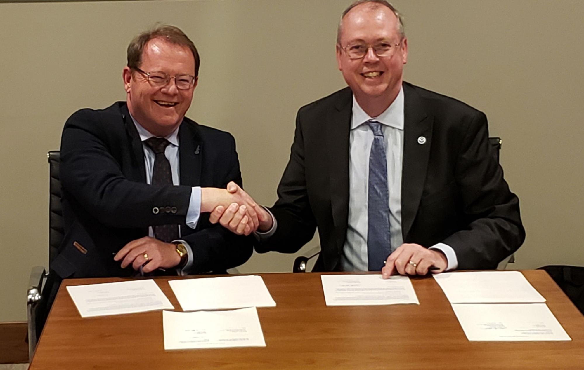 United Kingdom’s Met Office Markets Director Ian Cameron (left) and National Weather Service Director Ken Graham (right) sign a Memorandum of Understanding agreeing to increased collaboration on space weather operations