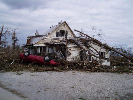 Photo of destroyed house with overturned car in Crosstown, MO