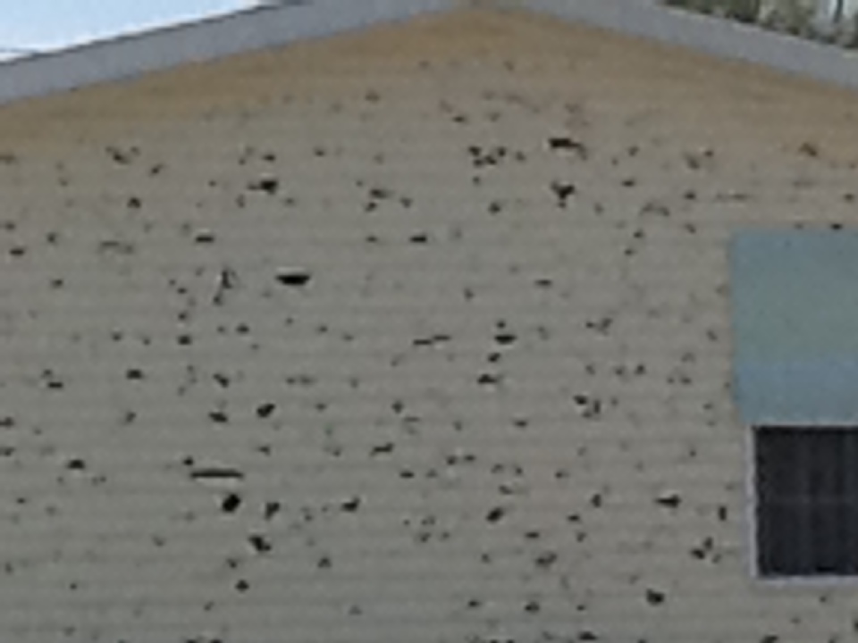 Home wall damaged by hail in south Oakland City, IN