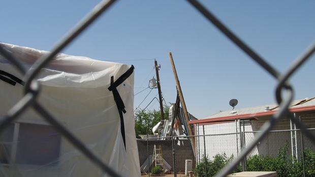 Power poles leaning to the southwest, south of the line of mobile homes that were damaged