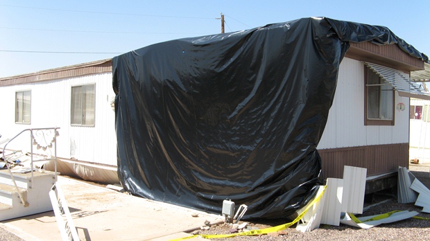 Brown mobile home with black tarp