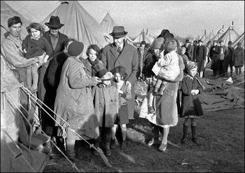 Harry Hopkins, WPA administrator, shown with refugees at a concentration camp in Forrest City, Ark., Feb. 1, 1937 during a stopover of President Roosevelt's flood committee on its tour of the stricken area. (AP Photo)