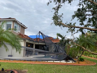 Tornado damage to house and pool cage; downed tree in yard