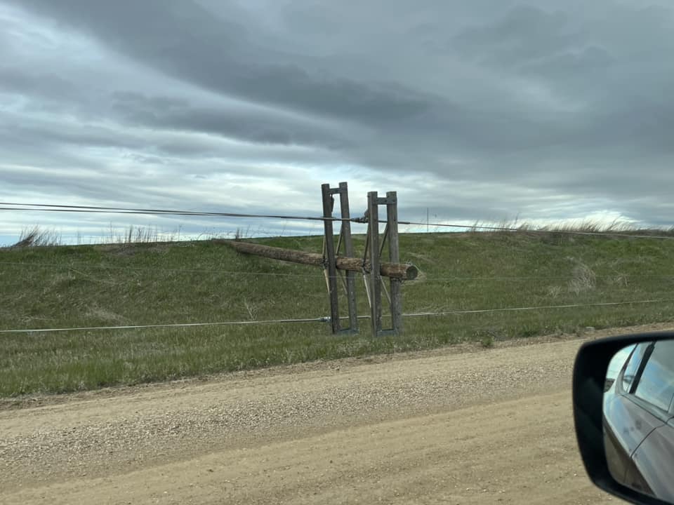 Downed power pole with dark clouds in the background